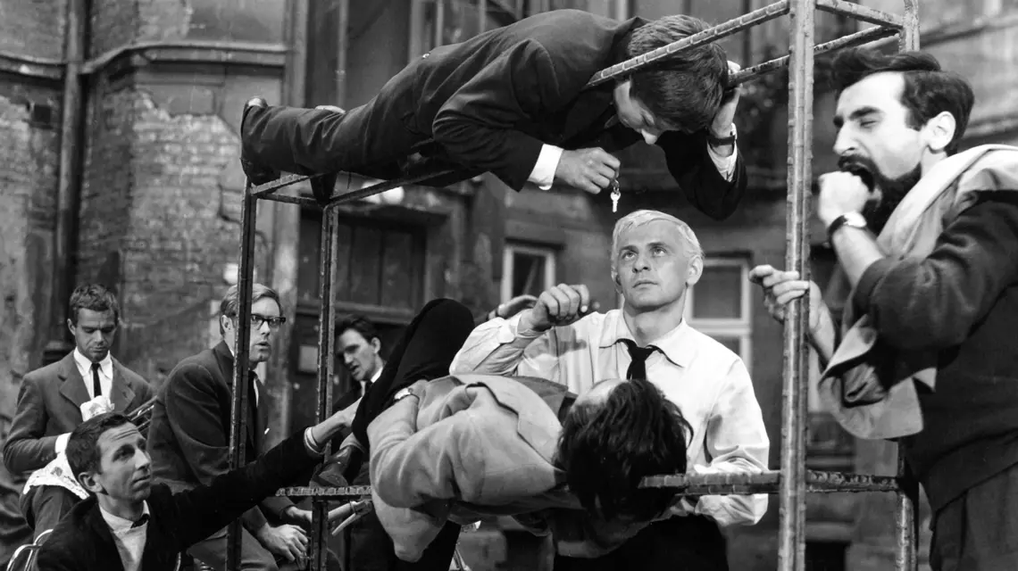 Tadeusz Łomnicki (w białej koszuli) na planie filmu „Niewinni czarodzieje”, 1960 r. Na zdjęciu po lewej także Andrzej Trzaskowski i Krzysztof Komeda, na górze trzepaka – Roman Polański // Fot. POLFILM / East News