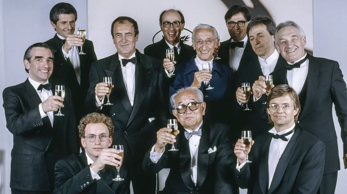 Andrzej Wajda (po prawej) z reżyserami – laureatami Złotej Palmy w Cannes, 1990 r. Wznoszą szampana ku czci Akiro Kurosawy (w pierwszy rzędzie w środku). M. in. od lewej Martin Scorsese, Claude Lelouch, Costa-Gavras, i Louis Malle. W dolnym rzędzie młody Steven Soderbergh, Kurosawa i Bille August // Fot. Micheline Pelletier / Sygma / Getty Images