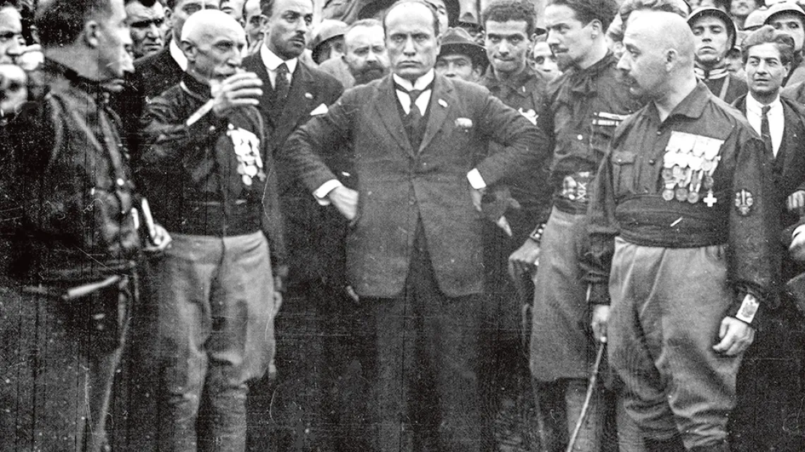 Benito Mussolini (w środku) z uczestnikami „marszu na Rzym”. Obok stoją Emilio de Bono (drugi z lewej), Italo Balbo (drugi z prawej) i Cesare Maria De Vecchi (pierwszy z prawej) – wszyscy oni tworzyli potem polityczno-wojskowe elity reżimu. Rzym, 25 paźdz / DOMENA PUBLICZNA