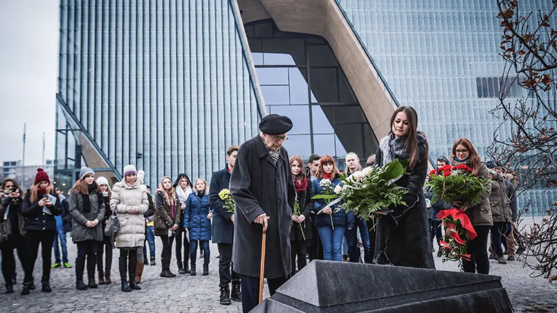 Władysław Bartoszewski z młodzieżą przed pomnikiem Rady Pomocy Żydom „Żegota”, w tle Muzeum Historii Żydów Polskich POLIN, 4 grudnia 2014 r. / / MAGDA STAROWIEYSKA / MUZEUM POLIN