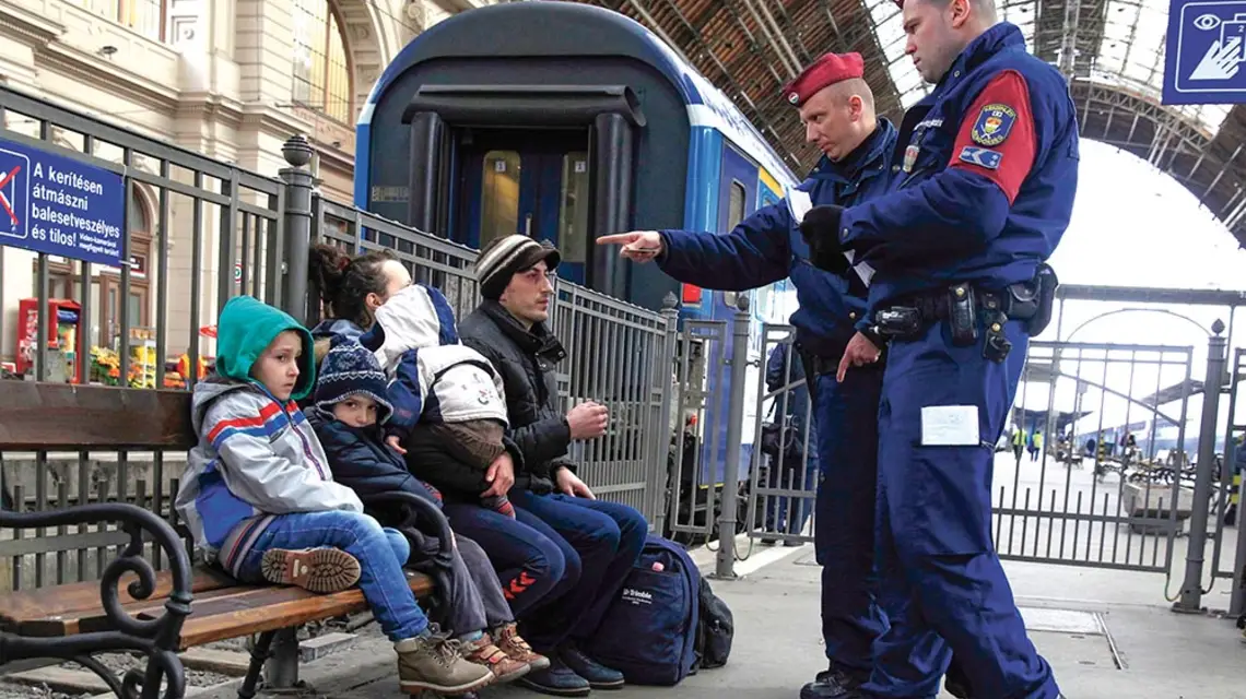 Węgierscy policjanci i imigranci z Kosowa na budapeszteńskim dworcu Keleti, luty 2015 r. / BERNADETT SZABO / REUTERS / FORUM