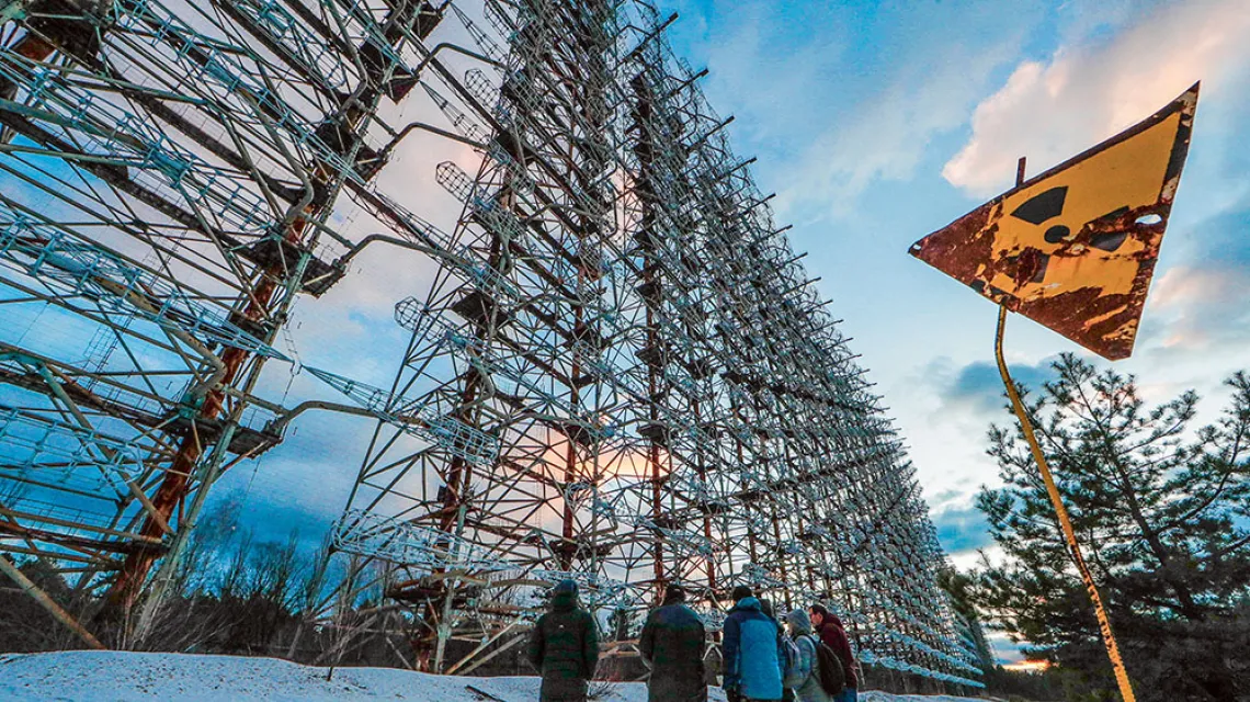 Turyści zwiedzają pozostałości po stacji radarowej „Duga” w Czarnobylu. Zwana „Okiem Moskwy”, podczas zimnej wojny stacja ta należała do sowieckiego systemu wczesnego ostrzegania. Styczeń 2020 r. / FOT. SERGEY DOLZHENKO / EPA / PAP / 