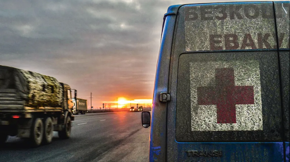 Poranek na drodze do Donbasu, z prawej bus z napisem „Bezpłatna ewakuacja”. 3 marca 2023 r. / ANTONINA PALARCZYK