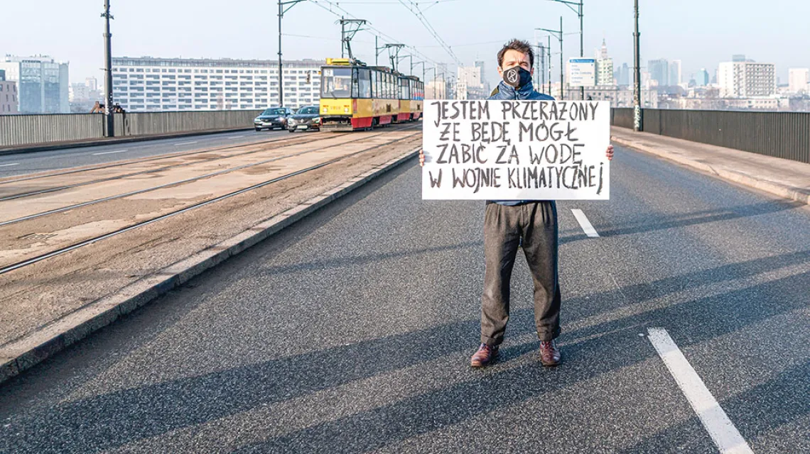Aktywista klimatycznego ruchu Extinction Rebellion zablokował jezdnię mostu Poniatowskiego. Warszawa, 25 lutego 2021 r. / MARTA BOGDANOWICZ / EAST NEWS