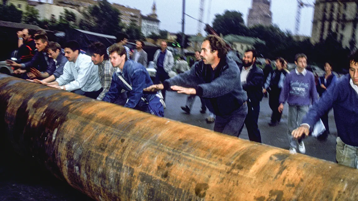 Demonstranci przetaczają pod rosyjski Biały Dom metalową rurę, aby zbudować barykadę i stawić opór puczystom. Moskwa, 20 sierpnia 1991 r. / ALAIN NOGUES / SYGMA / GETTY IMAGES
