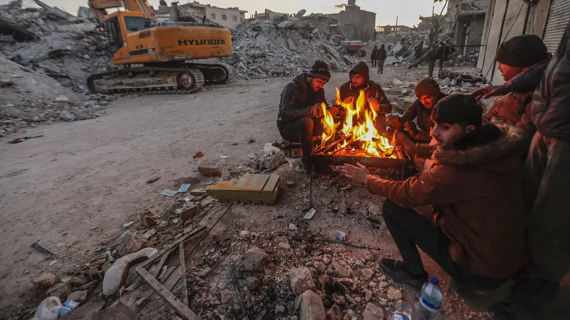 Mieszkańcy Aleppo ogrzewają się wśród gruzów, 8 lutego 2023 r. / FOT. AA / ABACA / FORUM / 