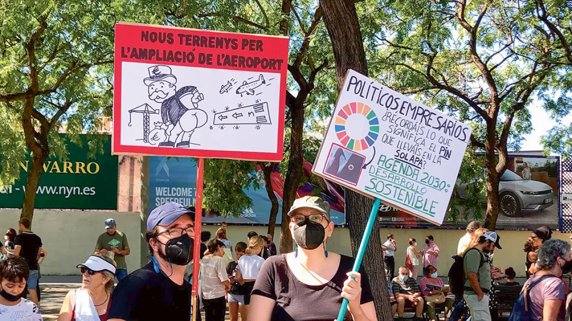 Eduardo i Monica manifestują przeciw rozbudowie lotniska El Prat. Ich transparenty to komentarz do projektu, który początkowo zgodnie popierali politycy z Madrytu oraz z Katalonii. Barcelona, 19 września 2021 r. / paulina maślona