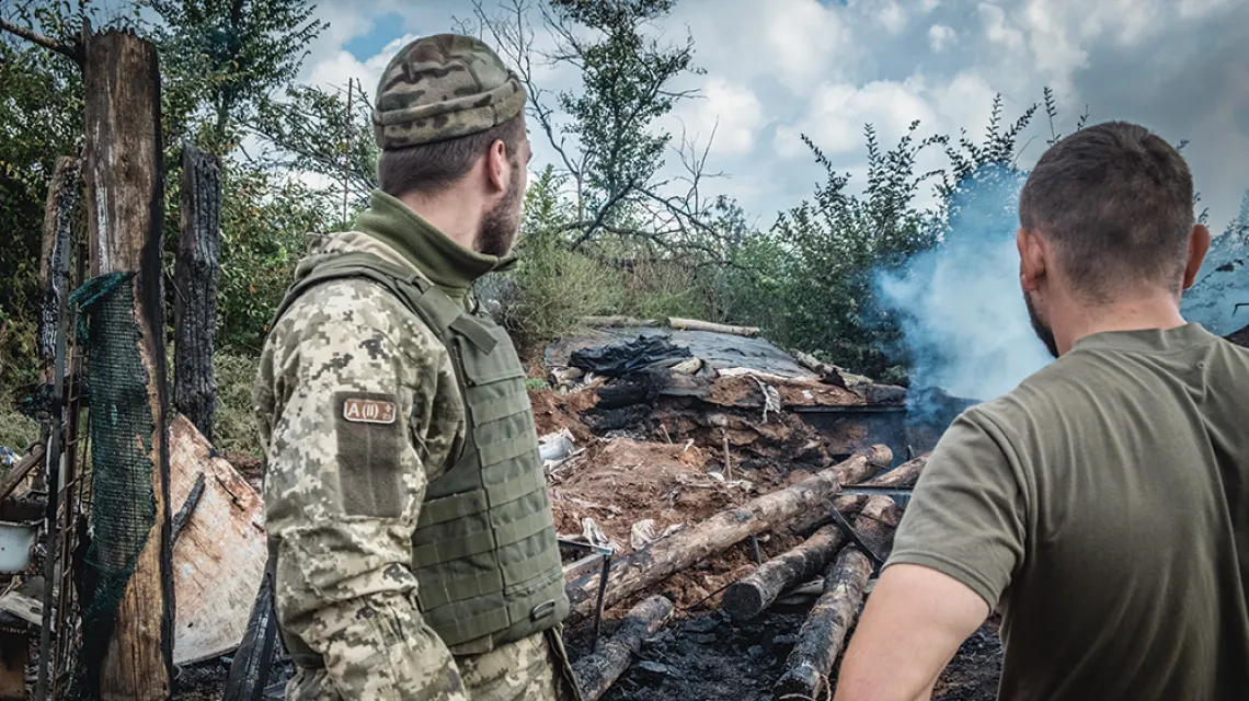 Ukraińscy żołnierze przed chwilą przeżyli ostrzał ich schronu, w tle jego resztki. Październik 2021 r. / monika andruszewska