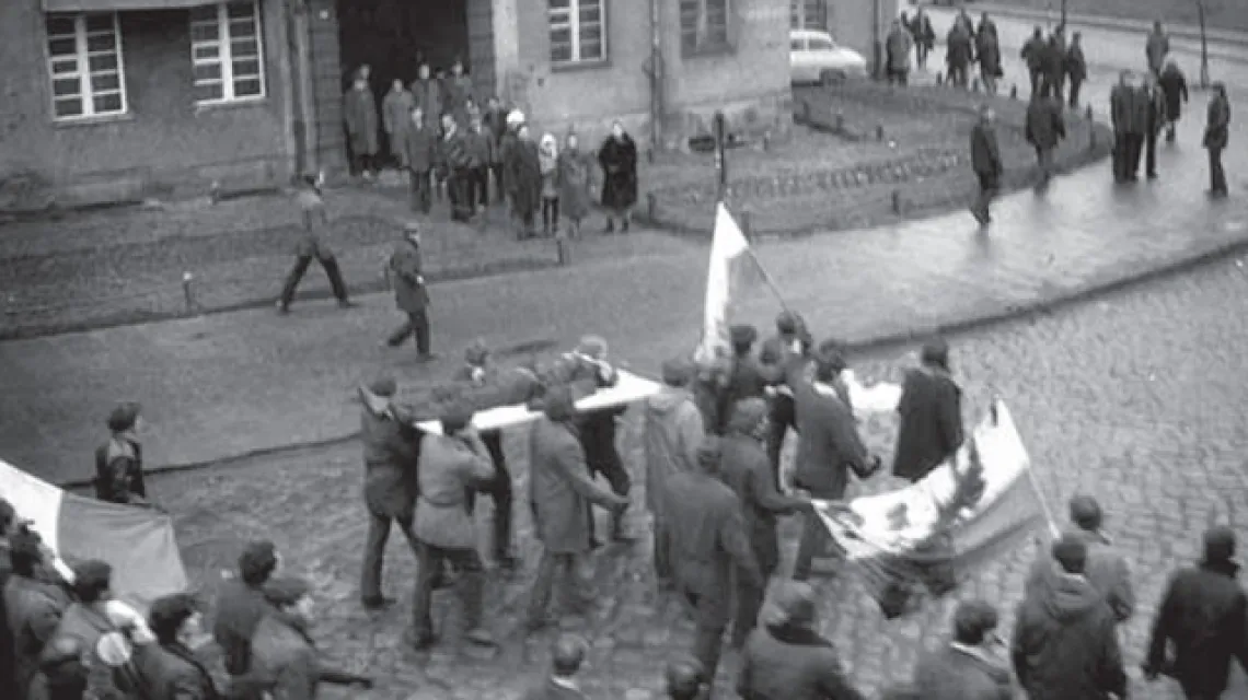 Gdynia, grudzień 1970 r.: demonstranci niosą na drzwiach zwłoki 18-letniego Zbigniewa Godlewskiego. Scena ta została uwieczniona w „Balladzie o Janku Wiśniewskim”. / fot. IPN / 