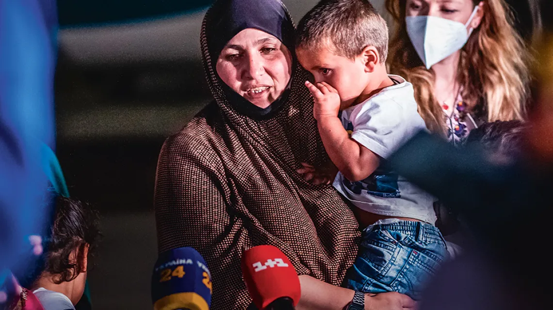 Amina, obywatelka Ukrainy, miała szczęście: ona i siedmioro jej dzieci zostało ewakuowanych z obozu jenieckiego w Syrii. Na zdjęciu opuszczają specjalny samolot, który przetransportował ich z Iraku. Lotnisko w Kijowie, 16 czerwca 2021 r. / ALINA SMUTKO