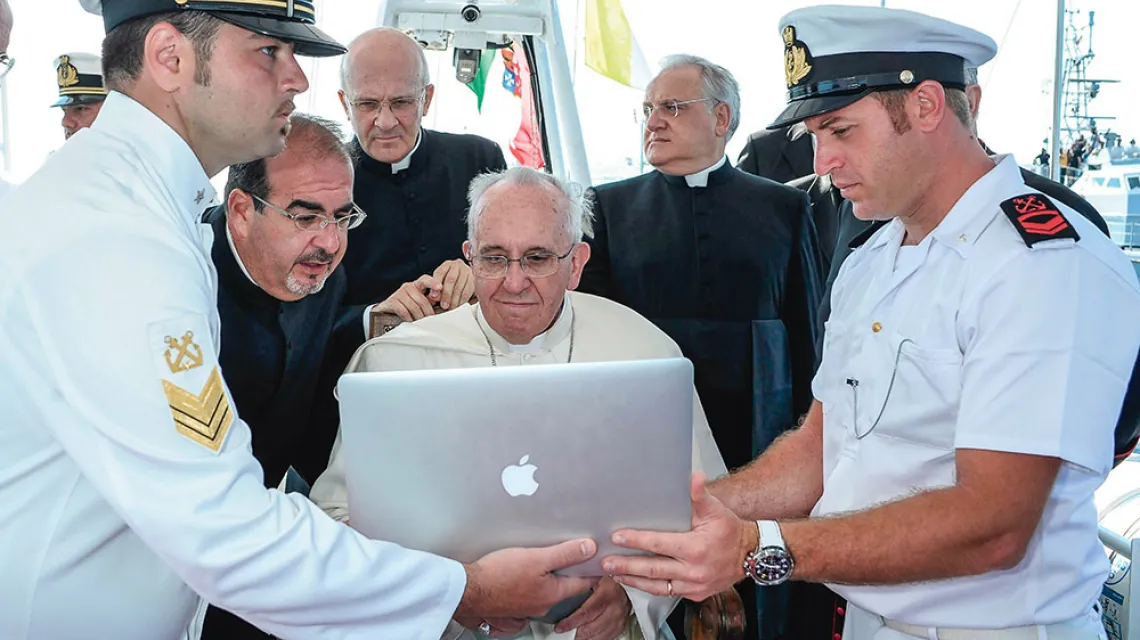Nowoczesne technologie umożliwiają bliższy kontakt z chrześcijanami z odległych rejonów świata. Na zdjęciu – papież Franiczek na pokładzie statku straży przybrzeżnej.  Lampedusa, lipiec 2013 r. / OSSERVATORE ROMANO / EIDON / REPORTER