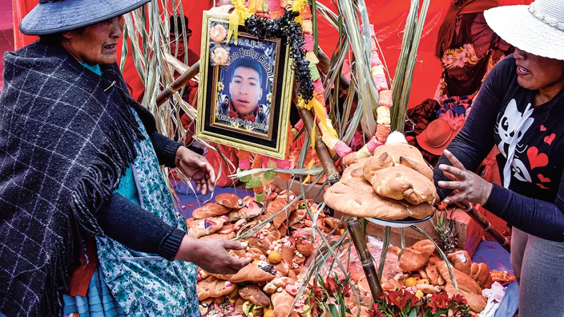 Juana Huallpa (z lewej) składa ofiarę z chleba na grobie swojego syna Eriberto na cmentarzu Mercedario w El Alto. Boliwia, 2 listopada 2020 r. / AIZAR RALDES / AFP / EAST NEWS