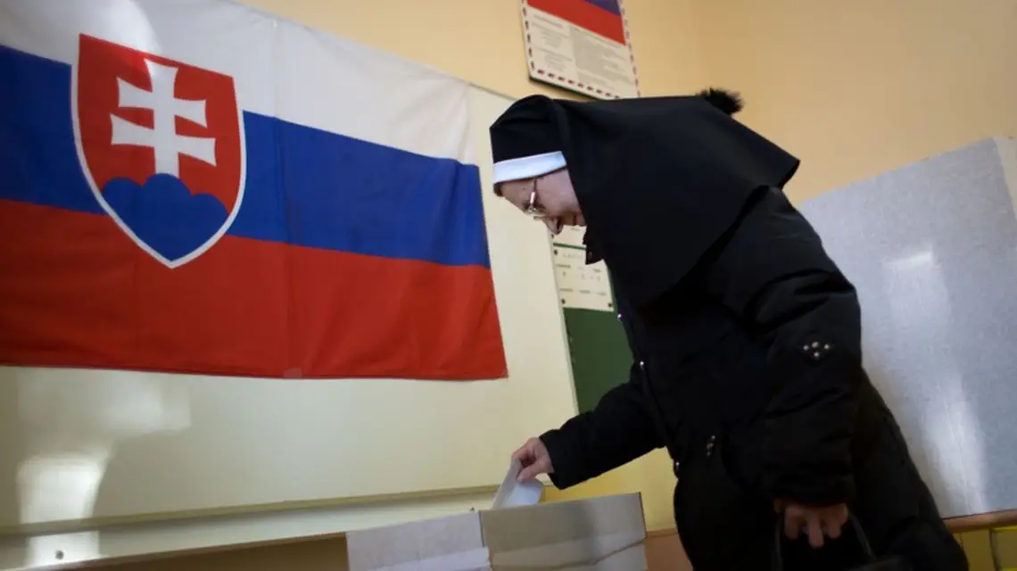 Zdjęcie pokazuje zakonnicę oddającą głos w słowackim referendum w sprawie małżeństw homoseksualistów, w tle na ścianie wisi flaga Słowacji. 7 lutego 2015 r.