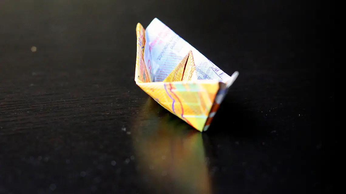 Banknot dziesięciofrankowy złożony w łódkę origami