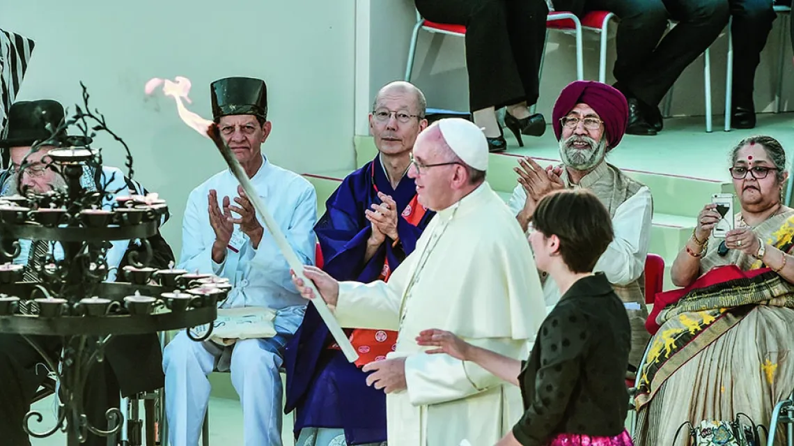 Franciszek zapala Świecę Pokoju na spotkaniu z przedstawicielami różnych religii. Bazylika św. Franciszka, Asyż, wrzesień 2016 r. / TIZIANA FABI / AFP / EAST NEWS