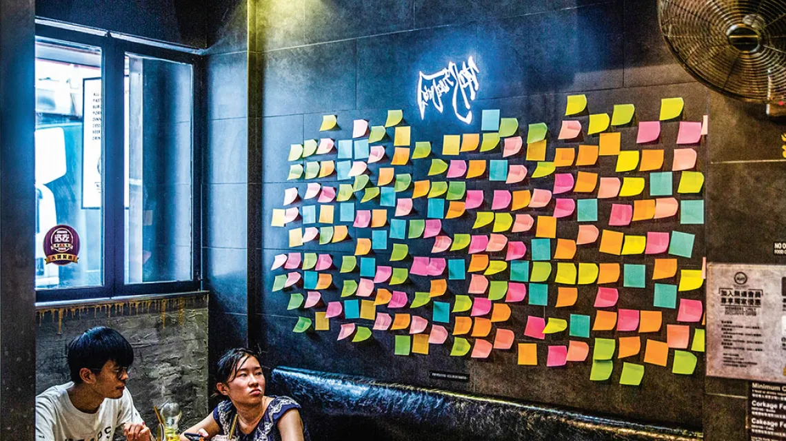 Mieszkańcy Hongkongu znajdują nowe sposoby na wyrażenie sprzeciwu: tu „ściana Lennona” w restauracji, której właściciel sympatyzuje z ruchem demokratycznym. Zapełniają ją kolorowe karteczki bez żadnych napisów. 3 lipca 2020 r. / ISAAC LAWRENCE / AFP / EAST NEWS