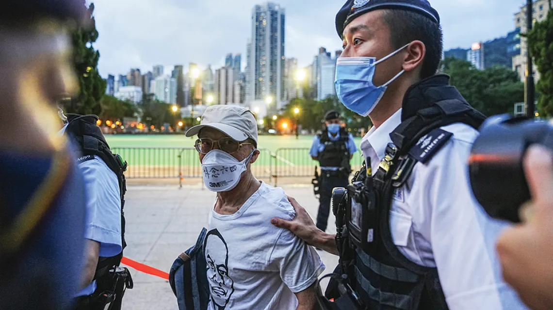 Policja zatrzymuje mężczyznę, który do Victoria Park – gdzie tradycyjnie miało odbyć się upamiętnienie w 33. rocznicę stłumienia demonstracji w Pekinie w 1989 roku – przyszedł z maseczką z napisem „Pamiętając Tiananmen”. Hongkong, 4 czerwca 2022 r. / LAM YIK / REUTERS / FORUM