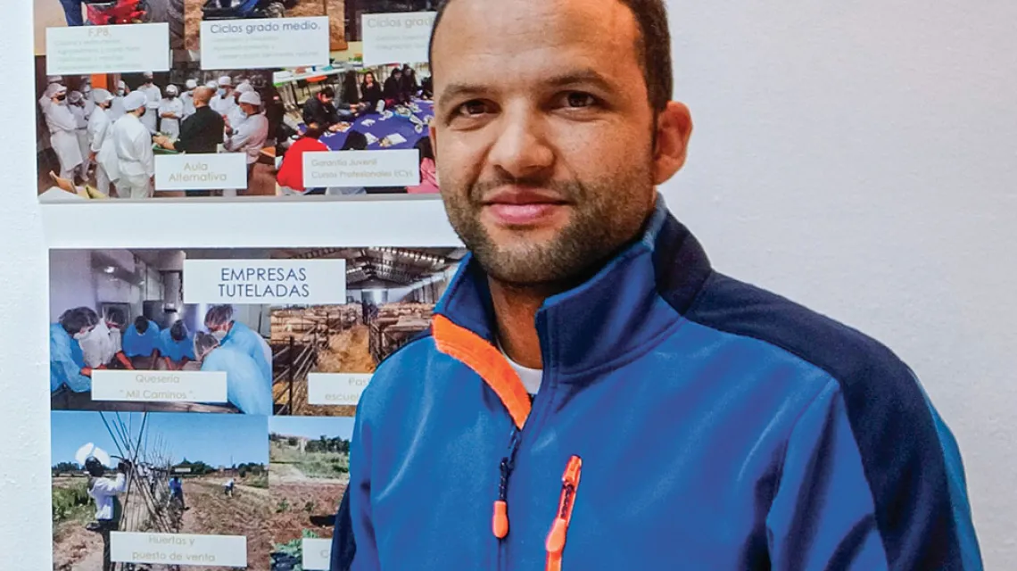 Ali Boujerfaoui na tle zdjęć przedstawiających działania fundacji Mil Caminos. Salamanka, 28 października 2022 r. / AGNIESZKA ZIELIŃSKA