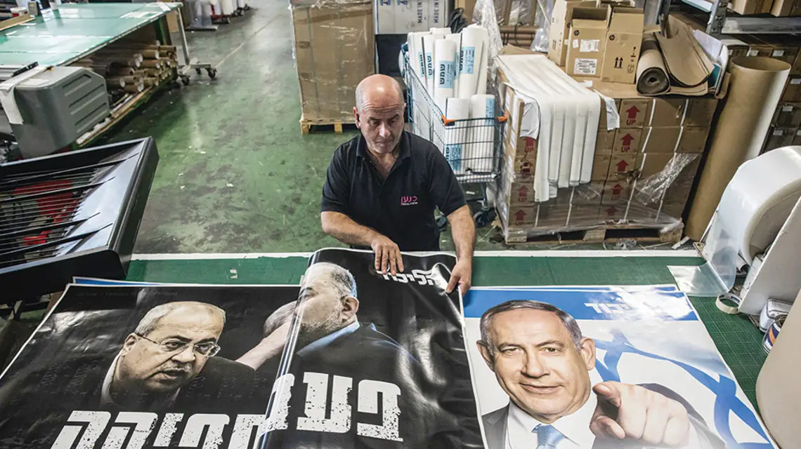 Pracownik drukarni przygotowuje plakaty Beniamina Netanjahu i partii Likud,Rosz ha-Ajin, Izrael, 19 października 2022 r. / AMIR LEVY / GETTY IMAGES
