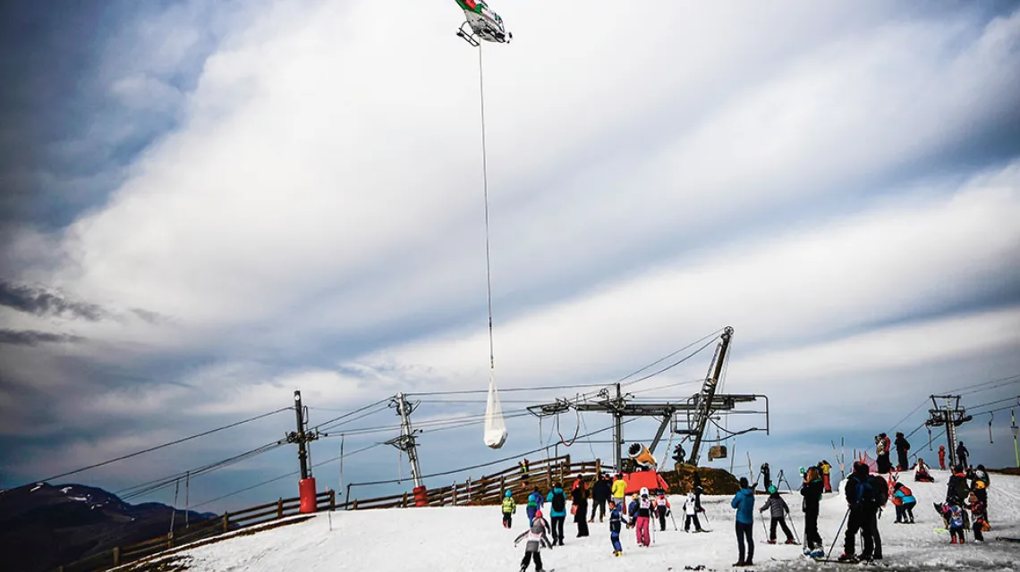 Śmigłowiec przewozi śnieg do ośrodka narciarskiego w Luchon-Superbagnères, Pireneje Francuskie, 15 lutego 2020 r. / ANNE-CHRISTINE POUJOULAT / AFP / EAST NEWS