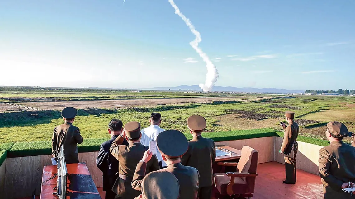 Kim Dzong Un (w środku, w białej koszuli) podczas testu nowej rakiety przeciwlotniczej. Niedatowane zdjęcie północnokoreańskiej agencji KCNA z maja 2017 r. / AFP PHOTO / KCNA VIA KNS / EAST NEWS
