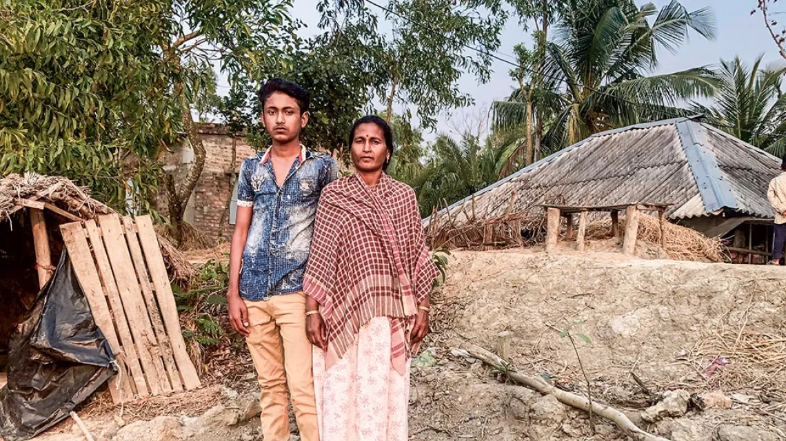 Onima, „tygrysia wdowa”, z synem Raju przy swojej chacie, dwa i pół roku po śmierci męża. Do dziś nie otrzymała gwarantowanej przez rząd rekompensaty i aby utrzymać kilkuosobową rodzinę, pracuje dorywczo na polu ryżowym. Wyspa Satjelia, Sundarbany, 2020 r / Marta Sawicka-Danielak