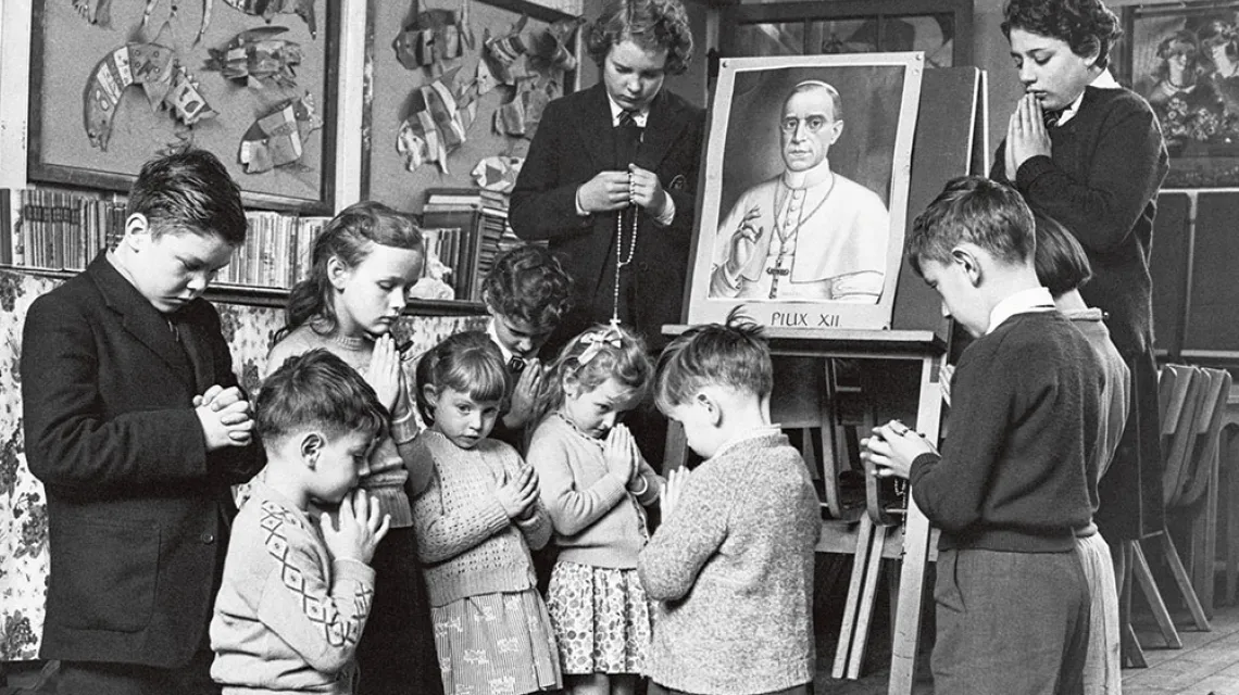 Dzieci z katolickiej szkoły w Rzymie modlą się o wybudzenie papieża Piusa XII ze śpiączki, październik 1958 r. / HULTON DEUTSCH / GETTY IMAGES