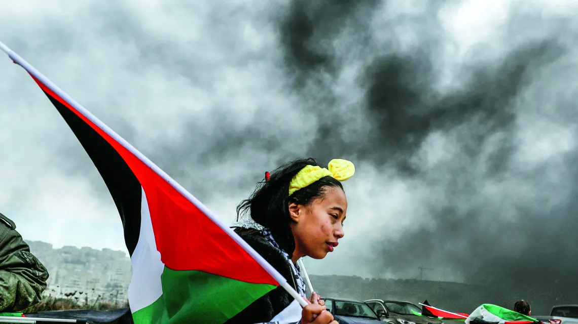 Dziewczyna z palestyńską flagą protestuje przeciwko bliskowschodniemu planowi pokojowemu Donalda Trumpa, Bilin, Zachodni Brzeg, luty 2020 r. / MOHAMAD TOROKMAN / REUTERS / FORUM