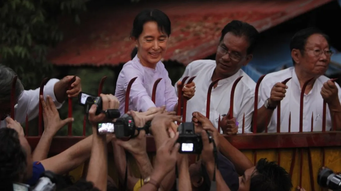 Aung San Suu Kyi przed bramą spornej posiadłości w czasach osadzenia w areszcie domowym, 2010 r. / Fot. AP / East News / 