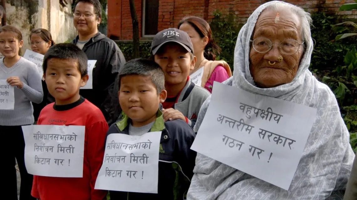 92-letnia Parbatee Rai z wnukami demonstruje przed rezydencją premiera w Katmandu, gdzie odbywały się rozmowy pokojowe. Napis na kartkach głosi: „Ustalcie datę wyborów do konstytuanty”. Nepal, 8 października 2006 r. /  / fot. ASSOCIATED PRESS / FOTOLINK