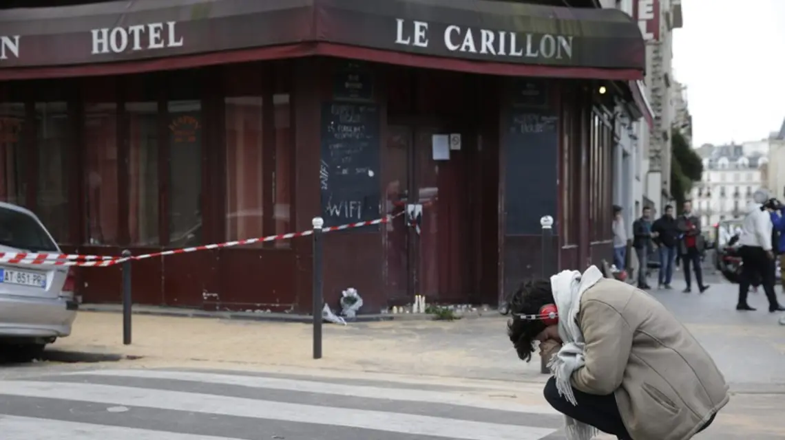 Kobieta pod restauracją Le Carillon w 10. dzielnicy Paryża, jednym z obiektów piątkowego ataku terrorystycznego, 14.11.2015 r. / / Fot. AFP PHOTO / KENZO TRIBOUILLARD