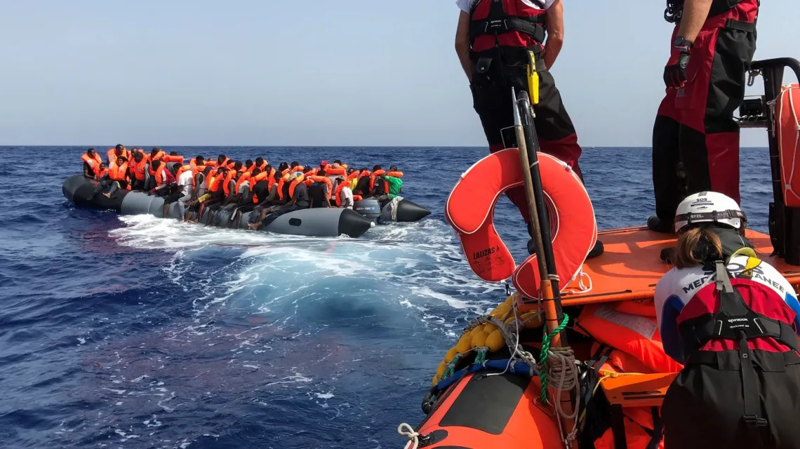 Akcja ratunkowa na Morzu Śródziemnym: członkowie załogi statku ratunkowego „Ocean Viking”, obsługiwanego przez francuskie organizacje pozarządowe zbliżają się do pontonu przewożącego migrantów. 9 sierpnia 2019 r. / FOT. ANNE CHAON/AFP/East News / 