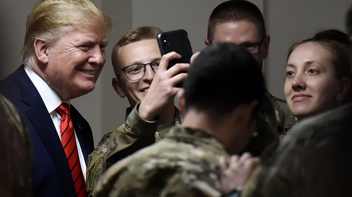 Donald Trump pozuje do zdjęć z amerykańskimi żołnierzami podczas wizyty zorganizowanej z okazji Święta Dziękczynienia w Afganistanie, 28 listopada 2019 r. Fot. OLIVIER DOULIERY/AFP/East News / 