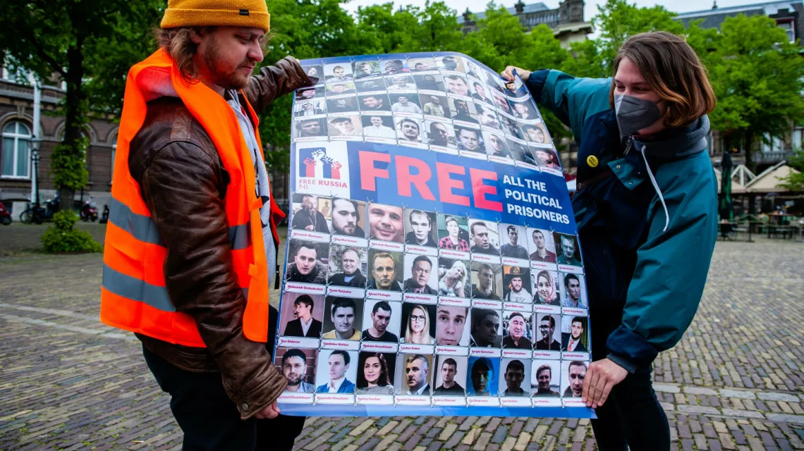 Para trzyma plakat z portretami więźniów politycznych w Rosji i na Białorusi podczas protestu w Hadze. 20 maja 2021 r. /Nur Photo/East News / 