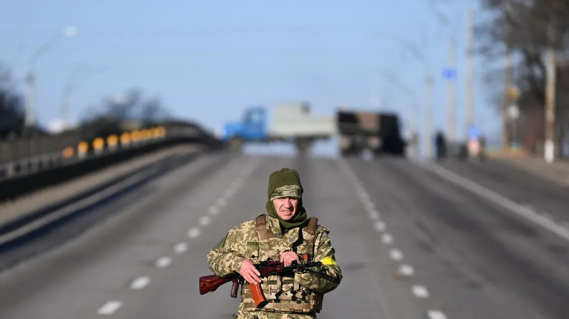 Ukraiński żołnierz patroluje drogę po zachodniej stronie Kijowa rankiem 26 lutego 2022 r. Fot. DANIEL LEAL/AFP/East News / 