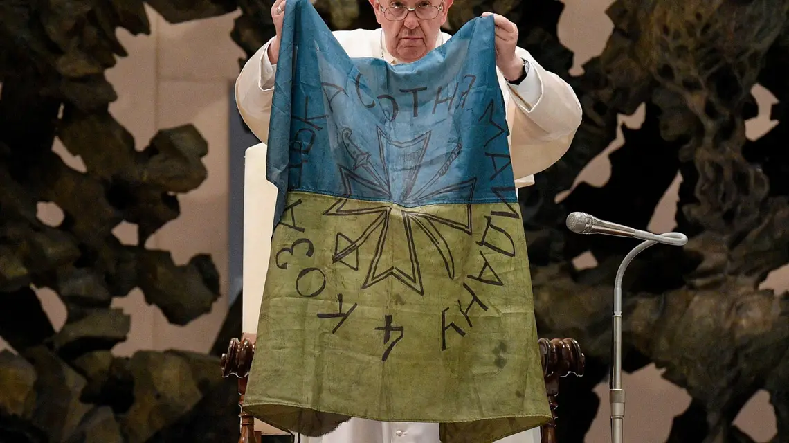 Papież Franciszek z flagą, którą otrzymał z Buczy, 6 kwietnia 2022 r. / HANDOUT/AFP PHOTO / VATICAN MEDIA/East News / 