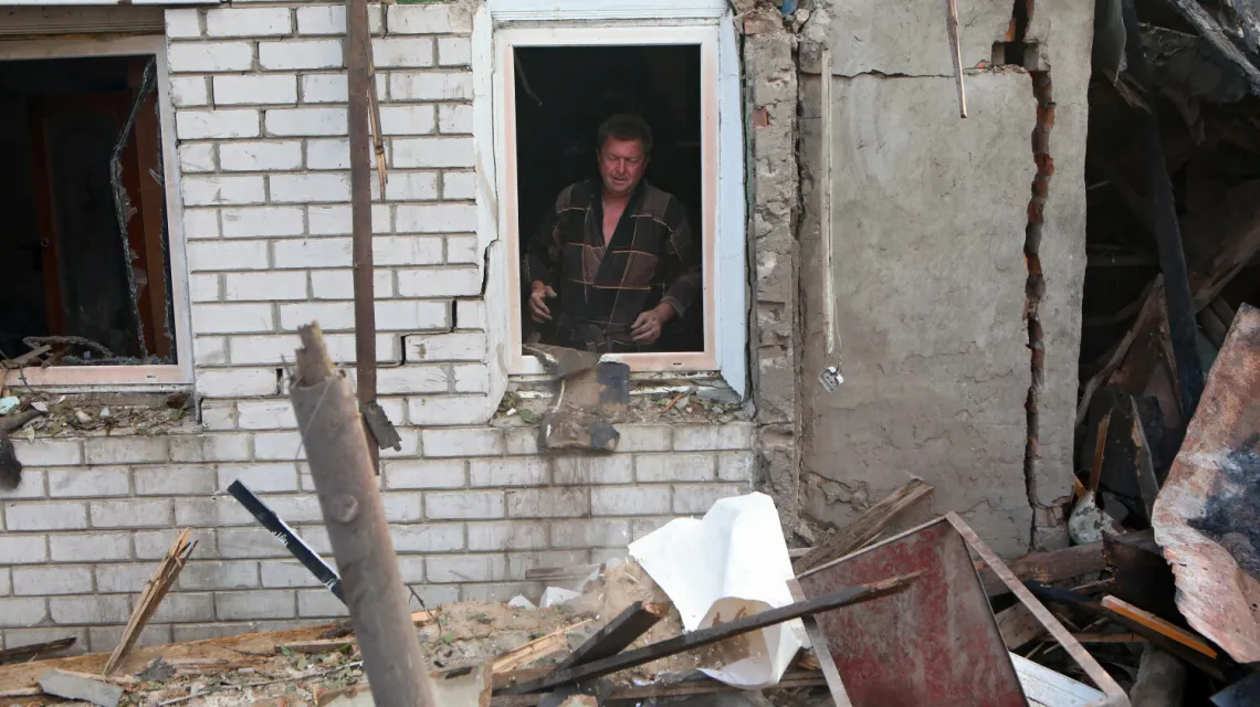 Roman Kravchenko w stoi w oknie swojego domu, który został zniszczony przez atak rakietowy na mieszkalne dzielnice Charkowa, 7 lipca 2022 r. / FOT. Vyacheslav Madiyevskyi/Ukrinform/East News / 