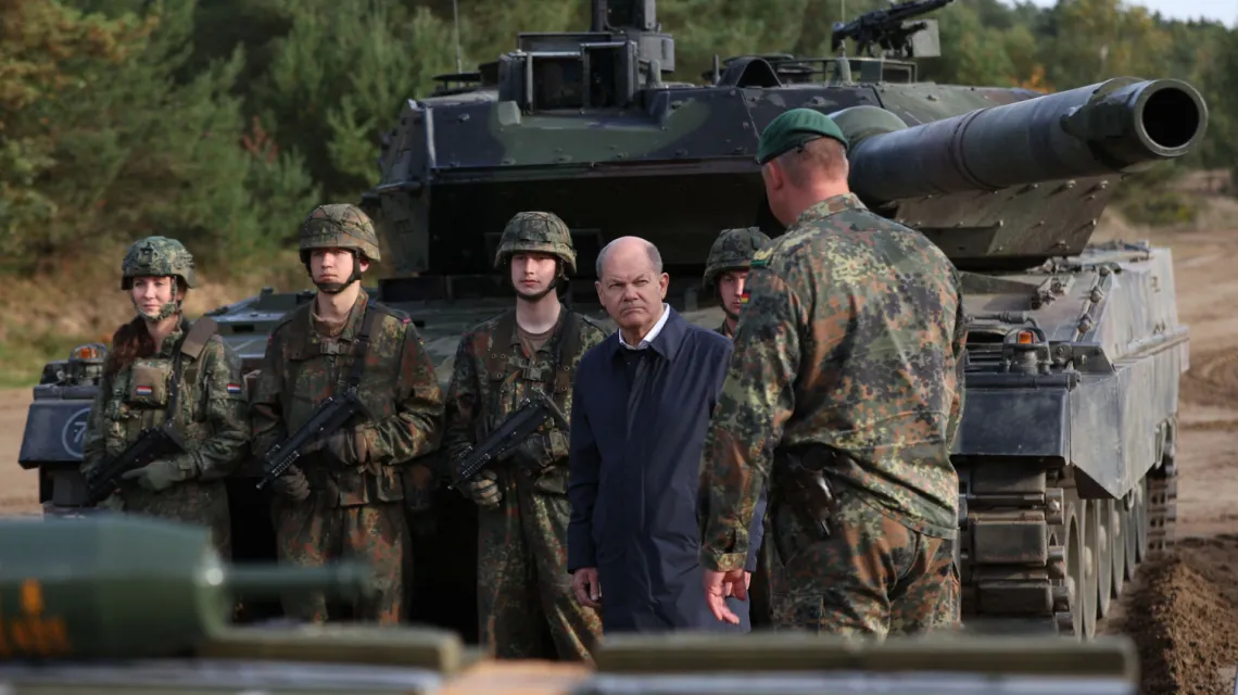 Kanclerz Niemiec Olaf Scholz podczas spotkania z żołnierzami; za nim czołg Leopard 2. Poligon w Ostenholz w północnych Niemczech, 17 października 2022 r. / FOT. RONNY HARTMANN/AFP/East News / 