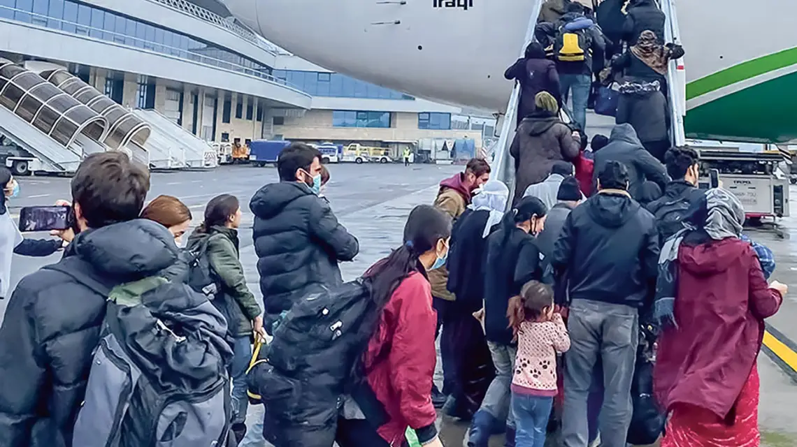 Irakijczycy i iraccy Kurdowie, którzy zdecydowali się wrócić z Białorusi do swojego kraju, wchodzą na pokład samolotu przysłanego po nich przez iracki rząd. Lotnisko w Mińsku, 18 listopada 2021 r. / fot. JAN HETFLEISCH / GETTY IMAGES / 