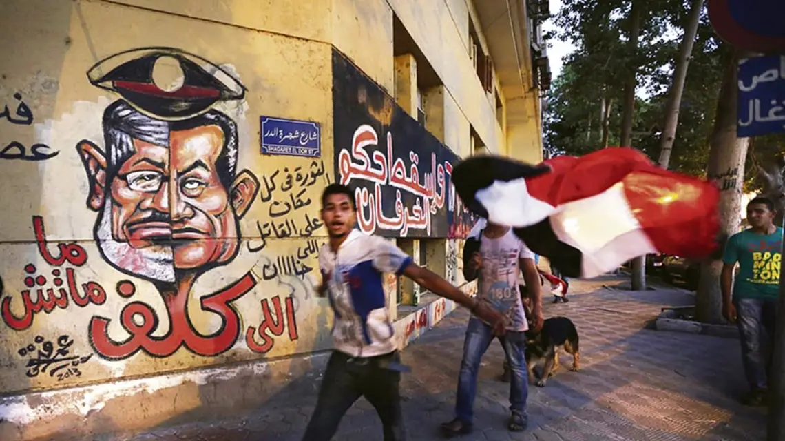 Mursi i Mubarak, dwaj byli prezydenci Egiptu, na graffiti naprzeciw Ministerstwa Kultury. Kair, 30 czerwca 2013 r. / Fot. Hiro Komae / AP / EAST NEWS