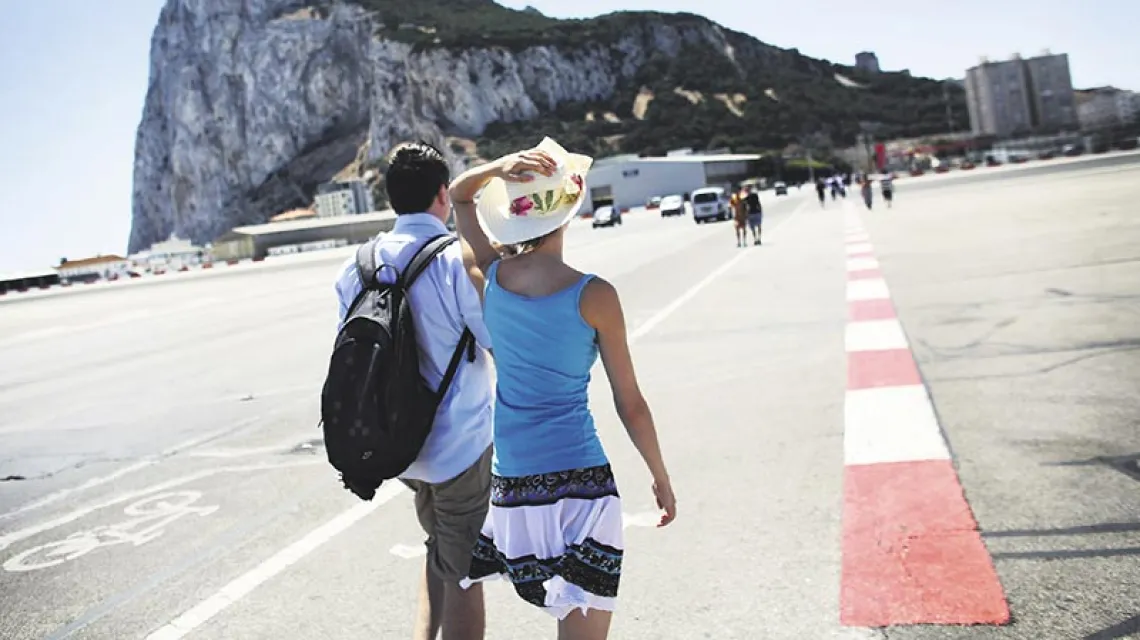 Wczasy pod „Skałą”: turyści przechodzą przez pas startowy lotniska w Gibraltarze. 7 sierpnia 2013 r.  / Fot. Oli Scarff / GETTY IMAGES / FPM