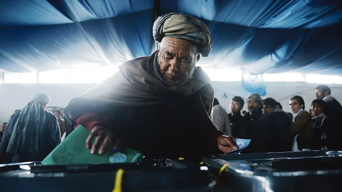 Afgańczycy stanęli w kolejkach, by móc zagłosować w wyborach prezydenckich. Frekwencja zaskoczyła nawet komisje wyborcze; w niektórych zabrakło kart. Kabul, 5 kwietnia 2014 r. / Fot. Shah Marai / AFP / EAST NEWS