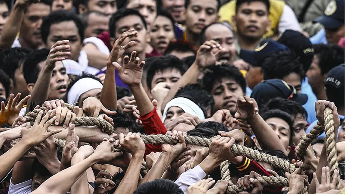 Podczas największej procesji na Filipinach wierni próbują dotknąć lin ciągnących wóz z figurą Jezusa – wierzą, że kontakt z nią uzdrawia. W tym roku jedna osoba została stratowana, a ok. 500 odniosło lekkie obrażenia. Manila, 9 stycznia 2015 r. / Fot. Dennis M. Sabangan / EPA / PAP