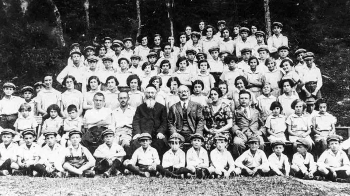 Kolonia letnia krakowskiego Domu Sierot w 1939 r. W otoczeniu dzieci siedzą: Kurzmann (z brodą), prezes stowarzyszenia prowadzącego Dom dr Rafał Landau, kierowniczka Domu Anna Feuerstein i jej mąż Juliusz. / Fot. Zbiory Grzegorza Siwora / z archiwum rodziny Kurzmannów