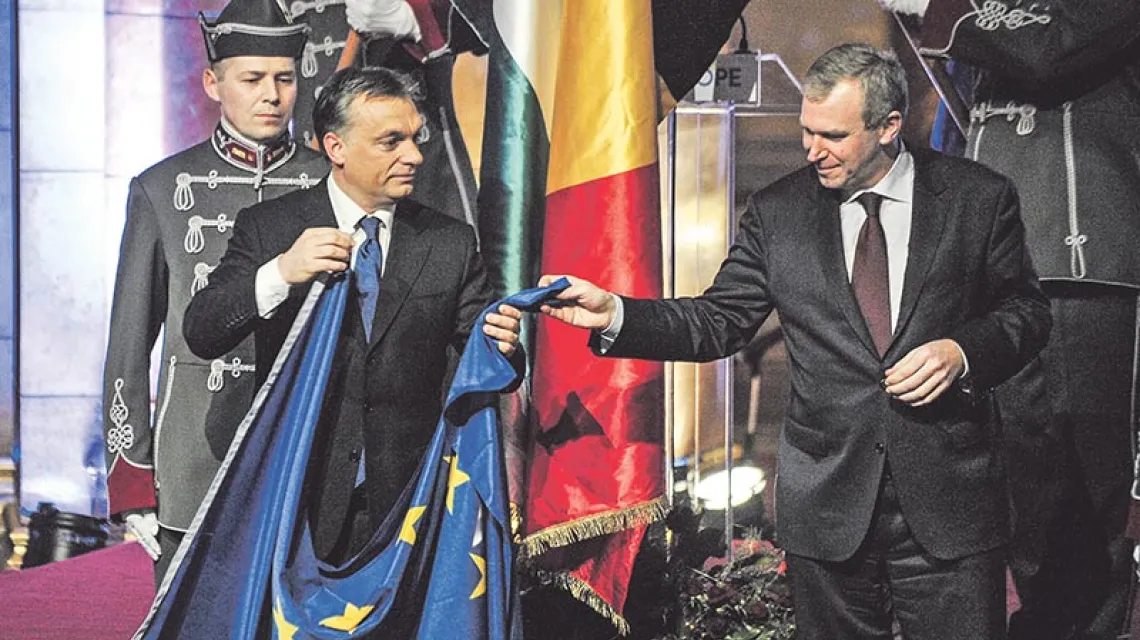 Premier Viktor Orbán (z lewej) i ówczesny premier Belgii Yves Leterme tuż przed wywieszeniem unijnej flagi w węgierskim parlamencie podczas uroczystości przejęcia przez Węgry rotacyjnego półrocznego przewodnictwa w Unii. Styczeń 2011 r.  / Fot. Attila Kisbenedek / AFP / EAST NEWS