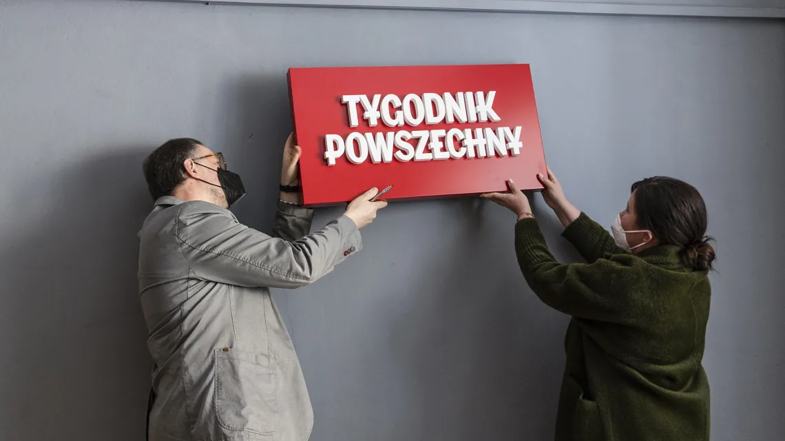 Anna Dziurdzikowska i Aleksander Kardyś zdejmują logo „Tygodnika Powszechnego” ze ściany pokoju konferencyjnego przy Wiślnej 12. Kraków, 29 kwietnia 2021 r. / fot. Grażyna Makara