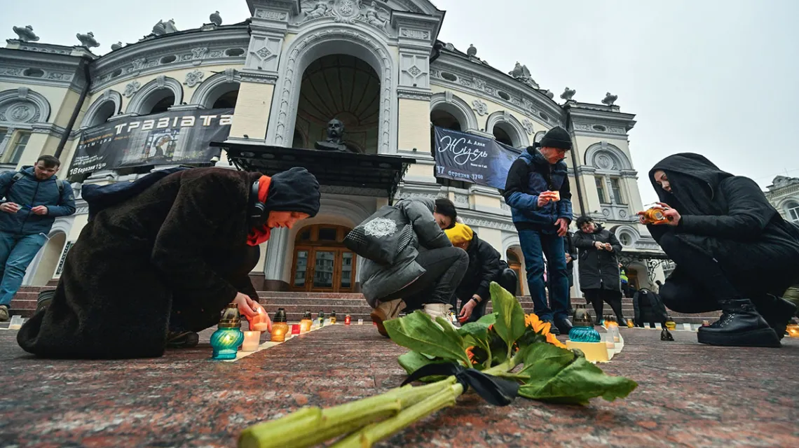 Przed operą w Kijowie, w rocznicę nalotu na teatr w Mariupolu, w którym zginęło kilkuset cywilów, ludzie układają ze świec słowo „Dzieci”. 16 marca 2023 r.  / SERGEI SUPINSKY / AFP / EAST NEWS / 