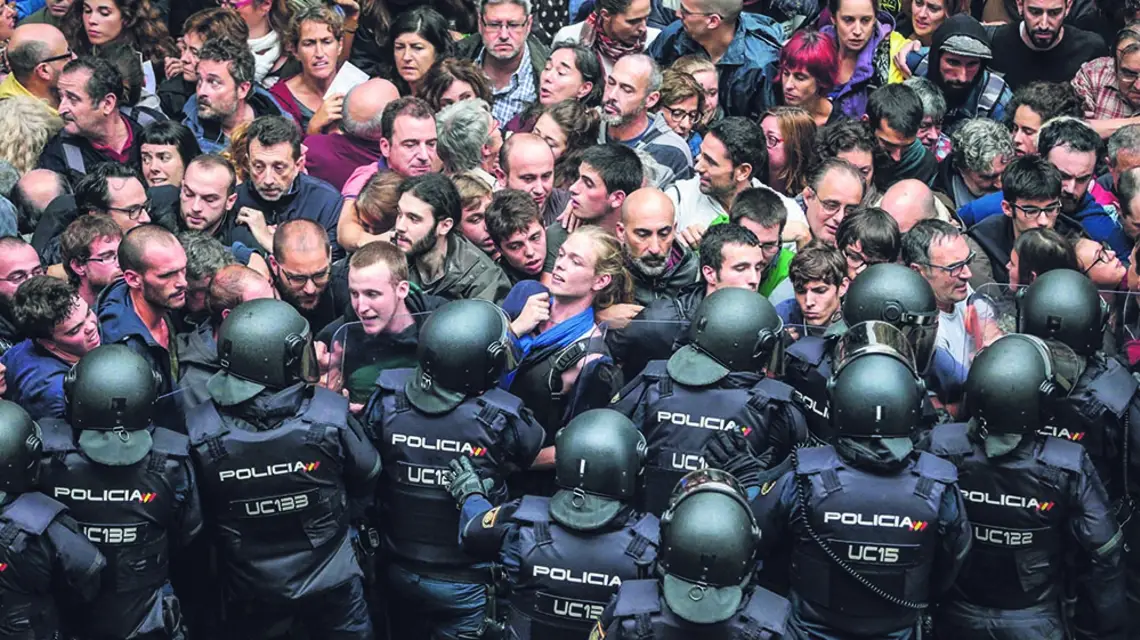 Policja hiszpańska otacza lokal wyborczy w Barcelonie, 1 października 2017 r. / ALBERTO ESTEVEZ / EPA / PAP