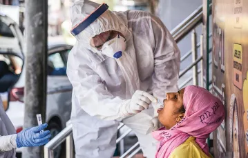 Pobieranie wymazu z gardła od kobiety podejrzanej o zakażenie wirusem SARS-CoV-2. Ajmer, Indie, 7 maja 2020 r. / SHAUKAT AHMED / PACIFIC PRESS / LIGHTROCKET / GETTY IMAGES
