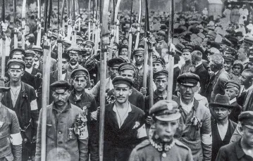 Oddział polskich robotników-ochotników uzbrojonych w kosy wyrusza na front wojny polsko-bolszewickiej, 1920 r. / ULLSTEINBILD / BEW
